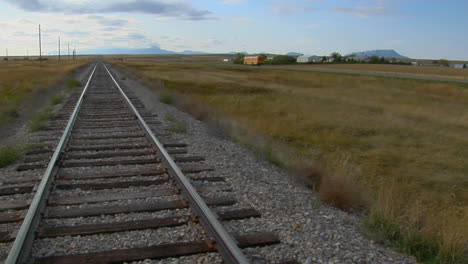 Un-Autobús-Escolar-Pasa-Una-Vieja-Vía-De-Ferrocarril-Que-Cruza-Una-Pradera