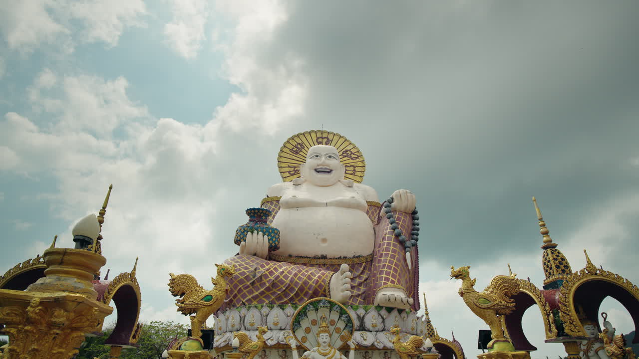 Statua del Grande Buddha circondata da elaborate decorazioni del tempio a Wat Plai Laem sull'isola di Koh Samui in Thailandia.