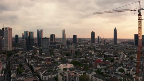 city skyline at sunset with skyscrapers and a construction crane