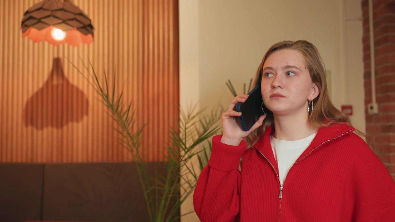 Young Woman Talking on a Smartphone in a Modern Interior