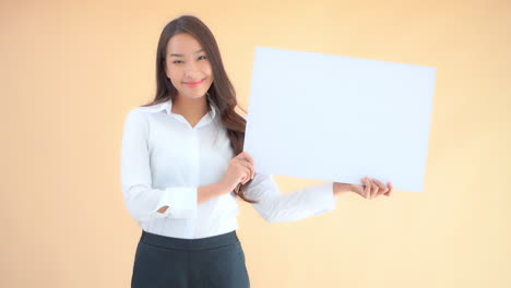 Elegant-Friendly-Asian-Woman-Holding-Up-White-Sign-for-Copy-Space