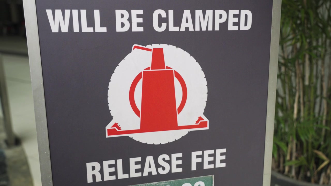 Close-up of an unauthorized parking warning sign in Malaysia, highlighting vehicle towing regulations and parking enforcement in an urban commercial area, UHD