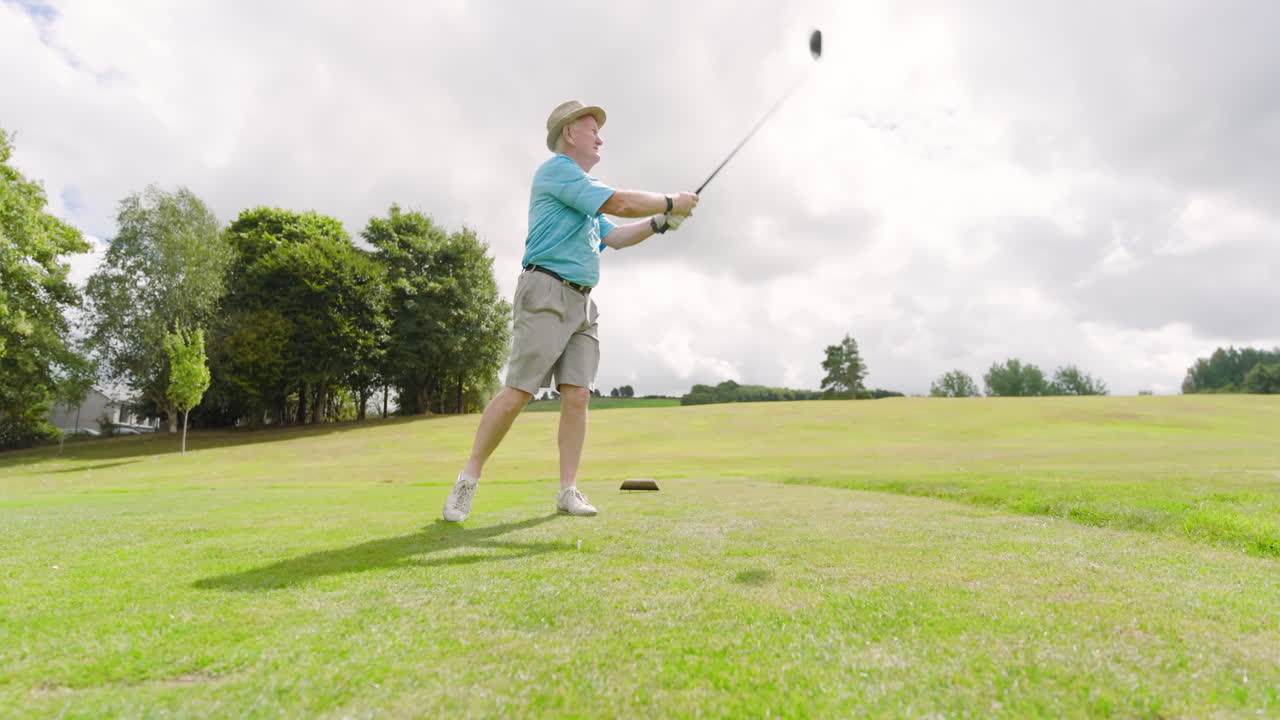 Male golf player wearing uniform, playing golf and knocking golf ball out on golf course, copy space
