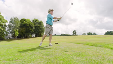 male golf player wearing uniform, playing golf and knocking golf ball out on golf course, copy space