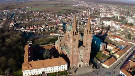 people walking in the street in front of dakovo cathedral, a catholic church in dakovo, slavonia, croatia