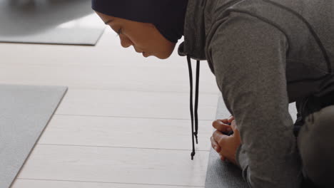 Gesunde-Yoga-Frau-Praktiziert-Posen.-Junge-Muslimische-Frau-Mit-Kopftuch-Genießt-Den-Fitness-Lebensstil-Und-Dehnt-Ihren-Körper-Beim-Training-Im-Studio-Mit-Einer-Gruppe-Gemischtrassiger-Frauen