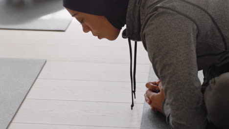 Mujer-De-Yoga-Saludable-Practicando-Poses-Joven-Musulmana-Con-Pañuelo-En-La-Cabeza-Disfrutando-De-Un-Estilo-De-Vida-Físico-Estirando-El-Cuerpo-Haciendo-Ejercicio-En-El-Estudio-Con-Un-Grupo-De-Mujeres-Multirraciales