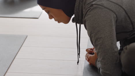 mujer de yoga saludable practicando poses joven musulmana con pañuelo en la cabeza disfrutando de un estilo de vida físico estirando el cuerpo haciendo ejercicio en el estudio con un grupo de mujeres multirraciales