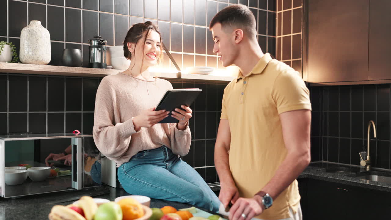 Couple in Kitchen Preparing Food with Tablet