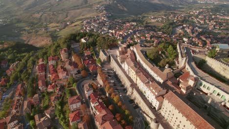 San-Marino,-Italy,-city-on-a-mountain,-city-building,-drone-tilt-up-view