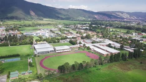 aerial travelling shot of running athletics track in green field