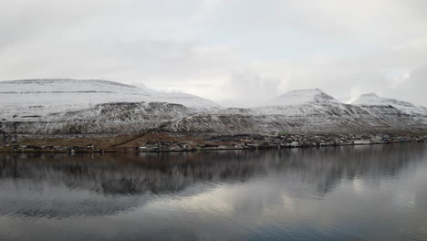 faroe islands, 4k aerial of skali town perched on the edge of the water