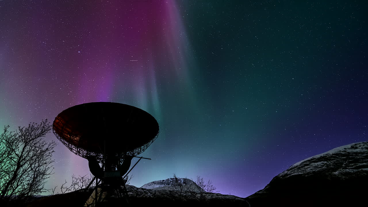 Magical dancing northern lights in night sky above EISCAT satellite, timelapse