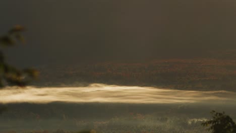 Timelapse-of-morning-fog-rolling-through-the-mountain-valley-with-autumn-colored-leaves