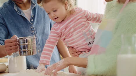 Handheld-view-of-parents-and-their-little-girl-baking-cookies