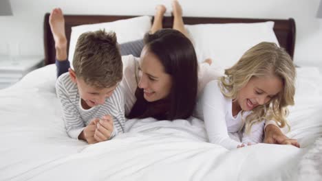madre jugando con sus hijos en el dormitorio en casa 4k