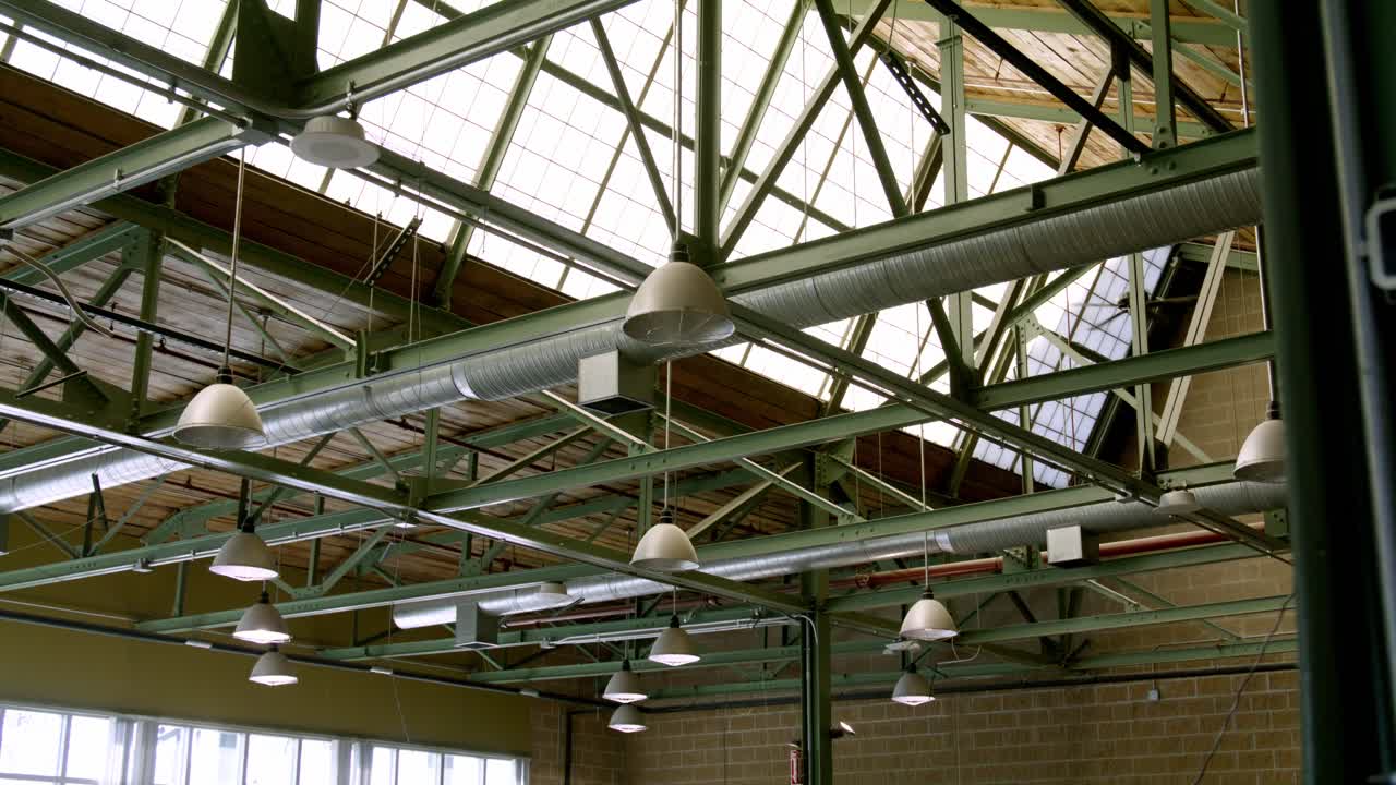 Industrial lighting in a warehouse with video dolly left to right wide.
