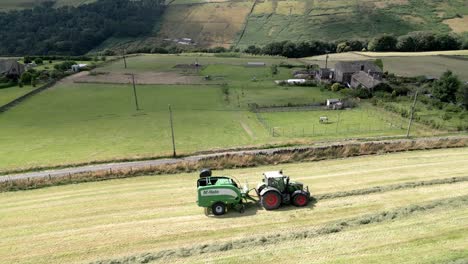 tractor verde cosechando heno en una vista aérea del paisaje rural