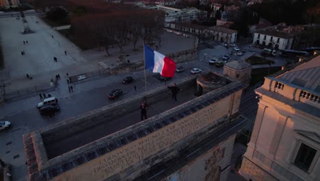 aerial view of people on rooftop with french flag at sunset