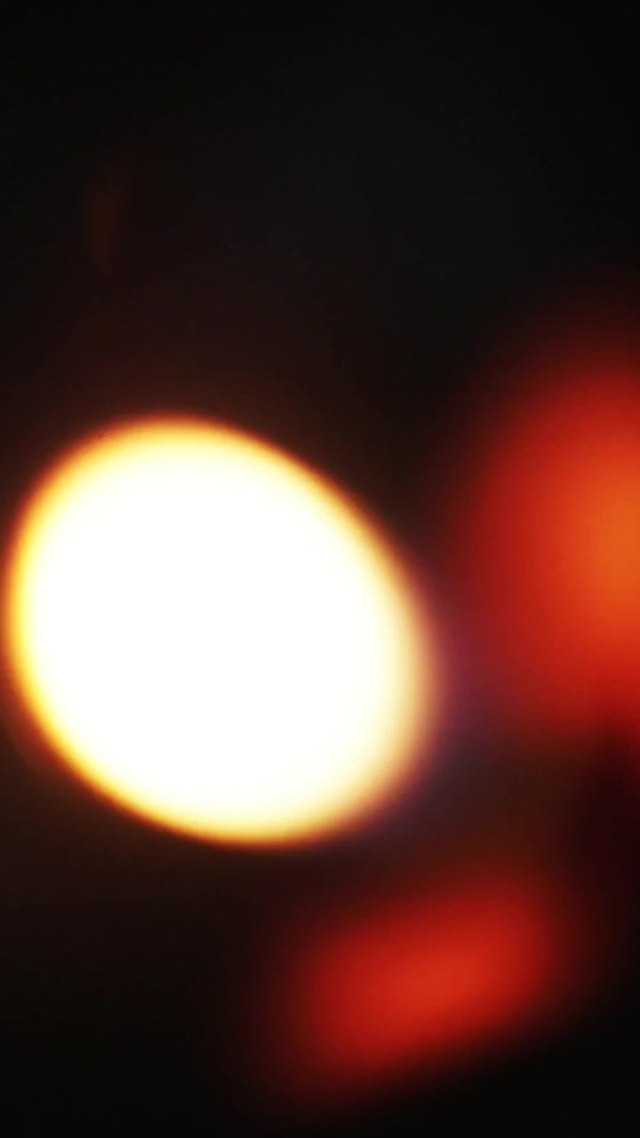 Perdite di luce astratte ed effetti bokeh su sfondo scuro.