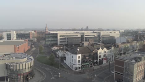 Drone-flying-above-misty-urban-empty-abandoned-town-COVID-virus-lock-down-descending-to-road-view