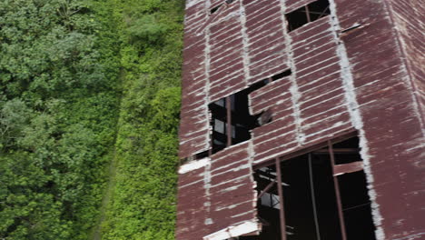 a weather-worn rusty abandoned old factory is being reclaimed by mother nature in the heart of the jungle