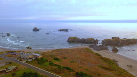 Agua-Serena-Junto-Al-Acantilado-Costero-Con-Formación-Rocosa-De-Cabeza-De-Elefante-En-El-Fondo-En-El-Parque-Estatal-Bandon-Beach,-Oregon