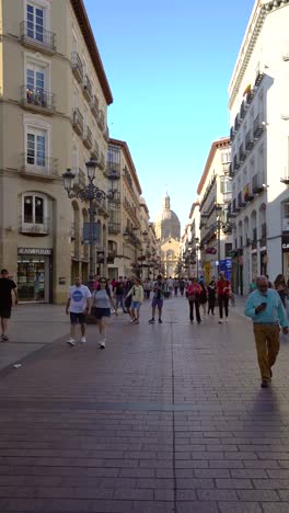 slow motion footage with people walking on city center of zaragoza. cathedral of zaragoza in background. pedestal street full with people. famous travel destination in spain. vertical fooatge