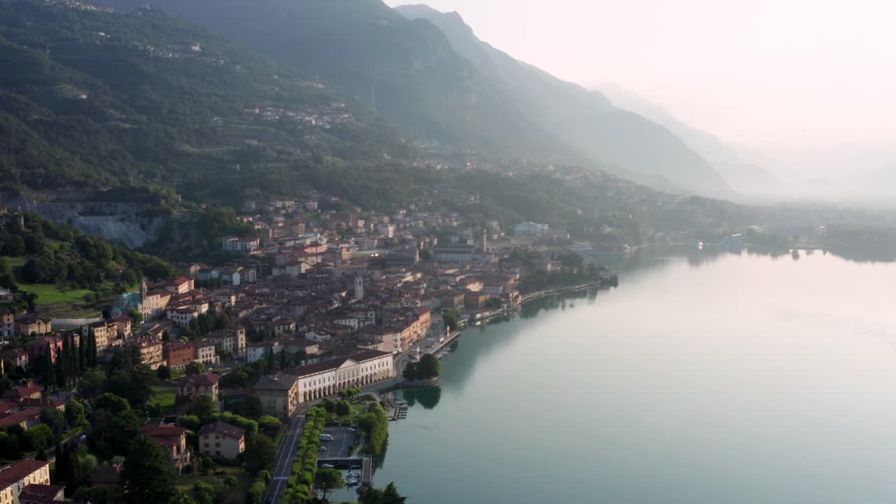 vista de drones del lago iseo al amanecer, a la izquierda la ciudad de lovere que corre a lo largo del lago, bergamo italia