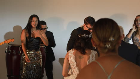 clip of a wedding where the newlyweds dance happily with their guests and bridesmaids.