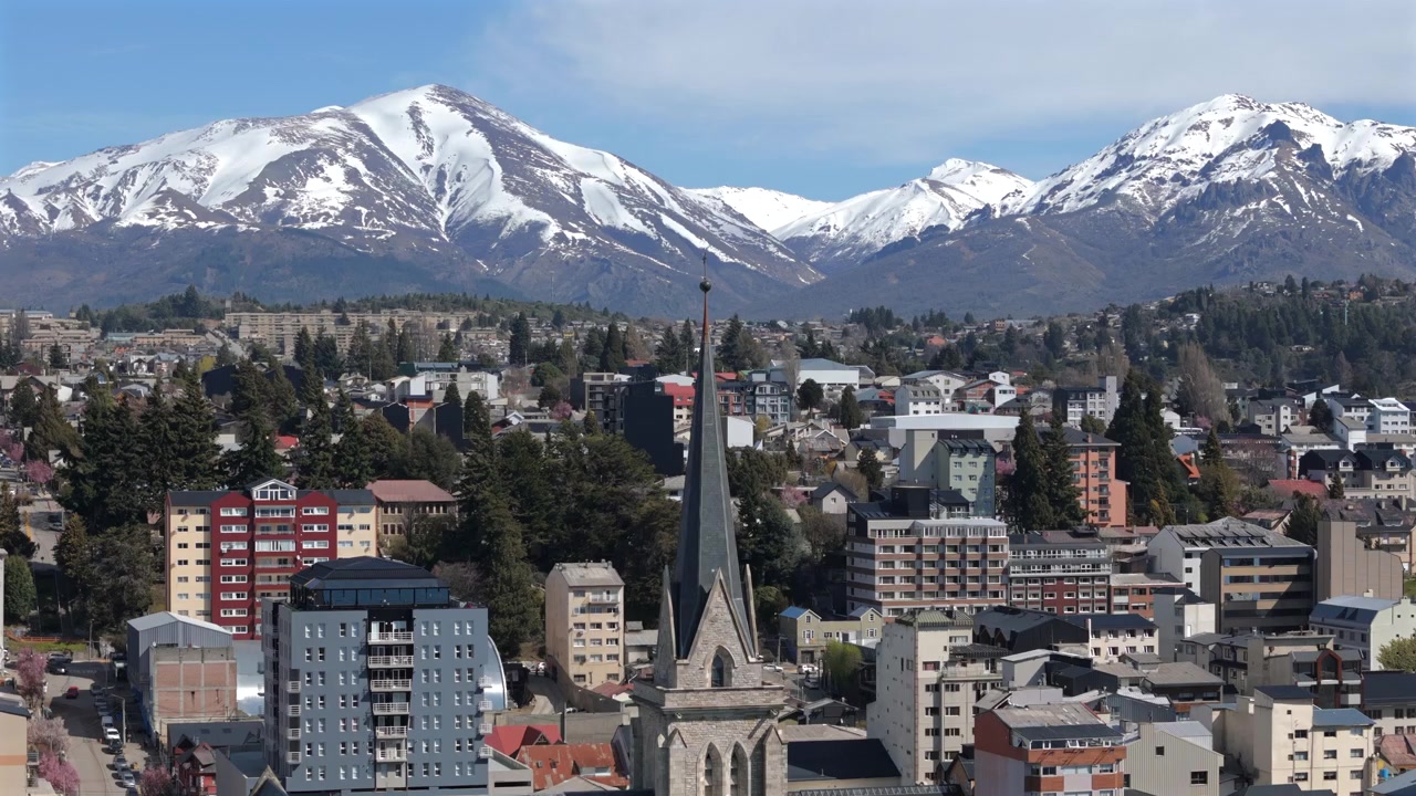 Nahuel Huapi Meryem Ana Katedrali, Bariloche, Rio Negro eyaleti, Patagonya, Arjantin'in Koruyucu Azizesi, arka planda And Dağları ile doğa ve şehir yaşamını harmanlayan, drone ile çekilmiş açığa çıkarma görüntüsü.
