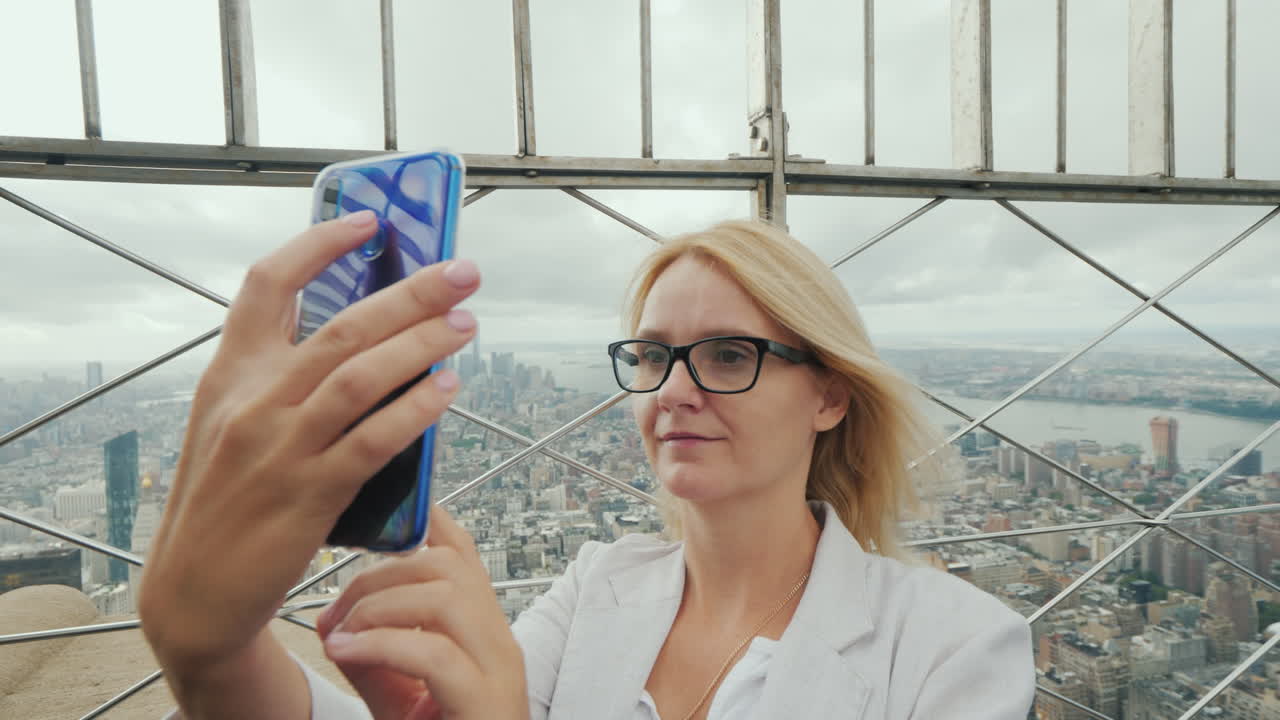 높은 지점에서 뉴욕시를 감상하는 여성의 뒷모습