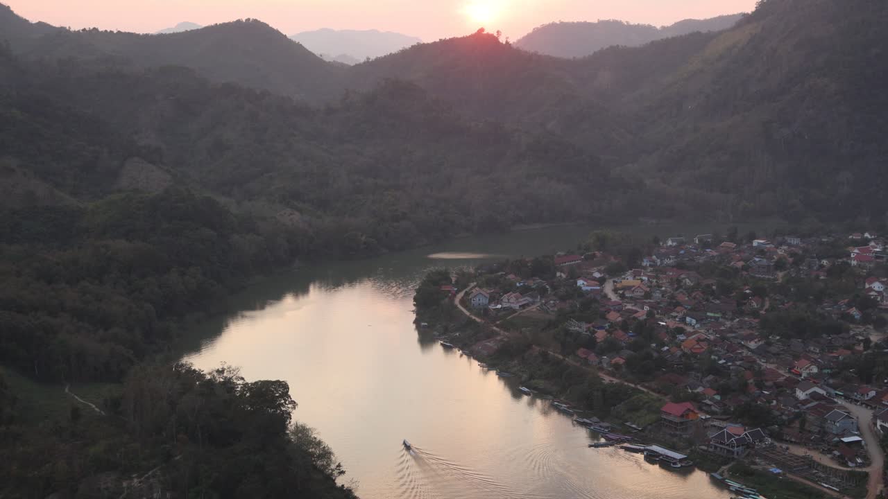 reflexión de la puesta de sol en una curva en el río en la ciudad montañosa de nong khiaw en laos, sudeste asiático