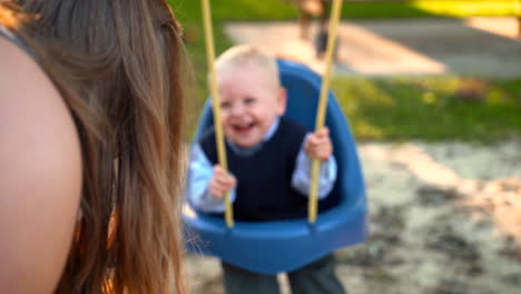 un bebé lindo en un columpio sonriendo y riendo