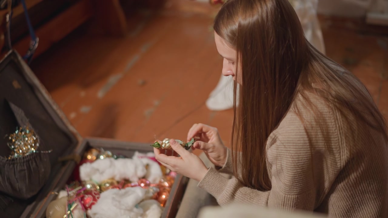 Person organiserer pyntegjenstander i oppbevaring. Enkeltperson sorterer forsiktig festdekorasjoner fra eske. Person fokusert på å arrangere fargerikt glitter og lys fra oppbevaringsbeholder for feiring