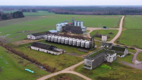 modern farm with shiny grain silos on an overcast day, drone view