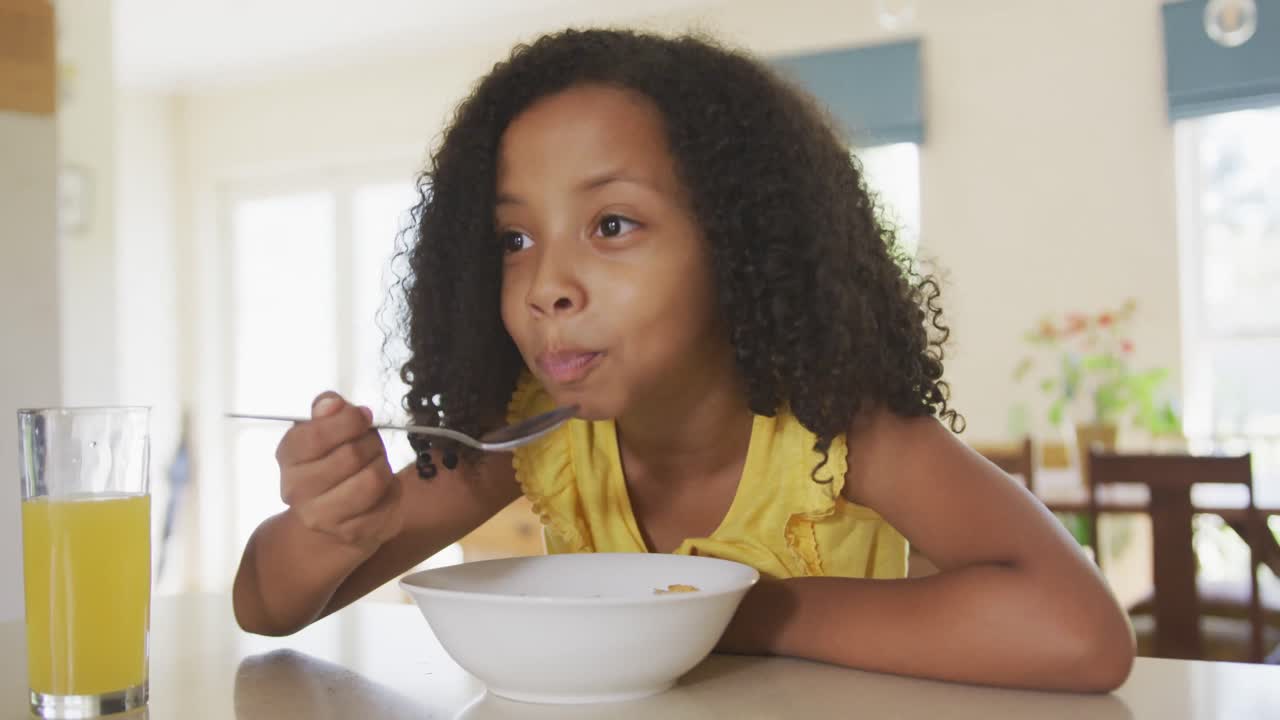 Vista frontale di una ragazza afroamericana che mangia cereali.