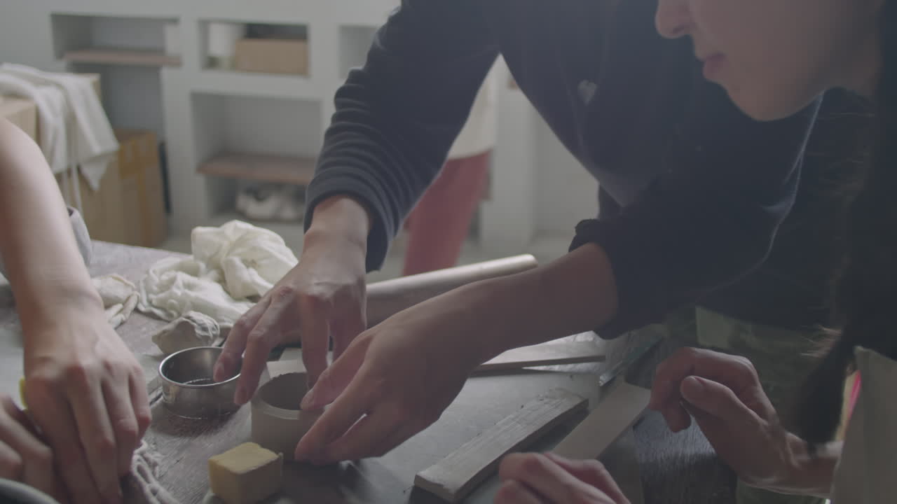 Pottery Teacher and Students Working with Clay at Ceramics Lesson