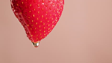 close-up of a single, wet strawberry with water droplets