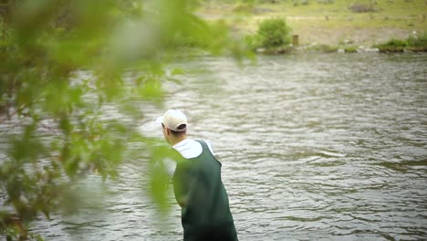 Slow-Motion-Shot-of-a-Caucasian-male-fisherman-casting-his-hook-while-Fly-Fishing