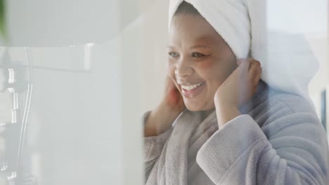 feliz afroamericana de talla grande mujer con una toalla en la cabeza en el baño, inalterada, cámara lenta