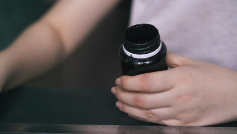 experienced tailor opens bottle with special leather paint