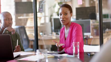 Afroamerikanische-Kollegen-Mit-Dokumenten-Auf-Dem-Tisch,-Die-Die-Arbeit-Im-Büro-Besprechen,-Zeitlupe