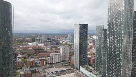 manchester deansgate aerial view flying between modern city centre skyscrapers overlooking downtown skyline