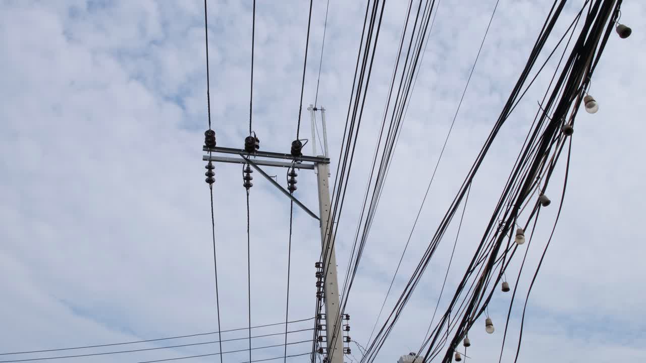 Entagled overhead electrical cables and wires in the middle of the city of Bangkok, in Thailand