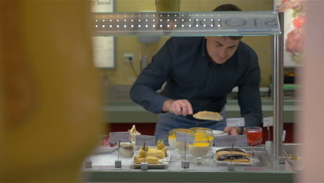 man choosing bakery in self-service buffet