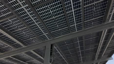 view from under a solar panel structure in a parking lot or similar use, aerial view