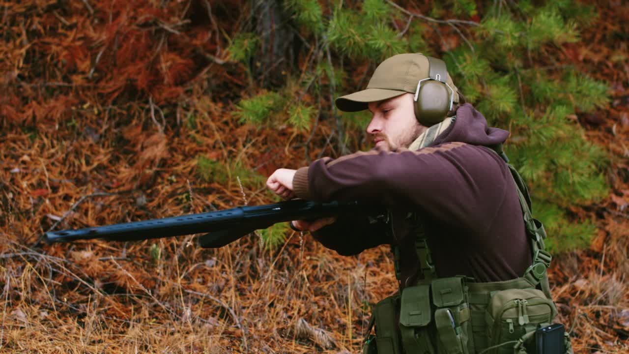 un cazador con auriculares dispara un arma 5