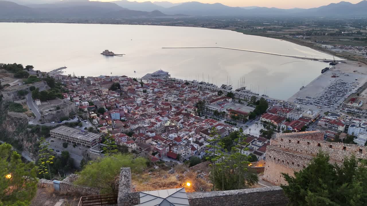 Peloponneso, Nauplia, vista aerea frontale dalla fortezza di Palamidi con vista sulla città di Nauplia e sulla baia durante il tramonto. Panorama mozzafiato con cielo rosa e blu.