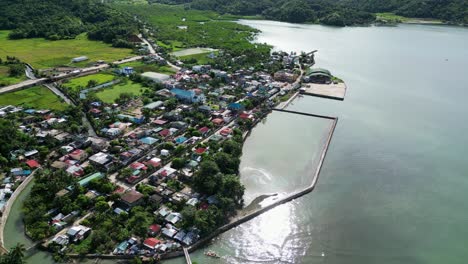 Stunning-flyover-shot-of-Philippine-island-village-and-turquoise-sea-waters-in-Baras,-Catanduanes